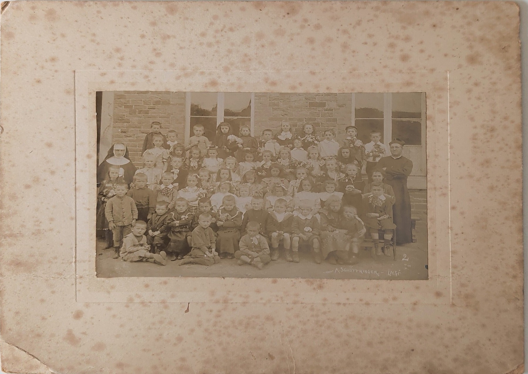 École Saint-Joseph : élèves avec une religieuse et un prêtre. Photographie non datée dans le document fourni.